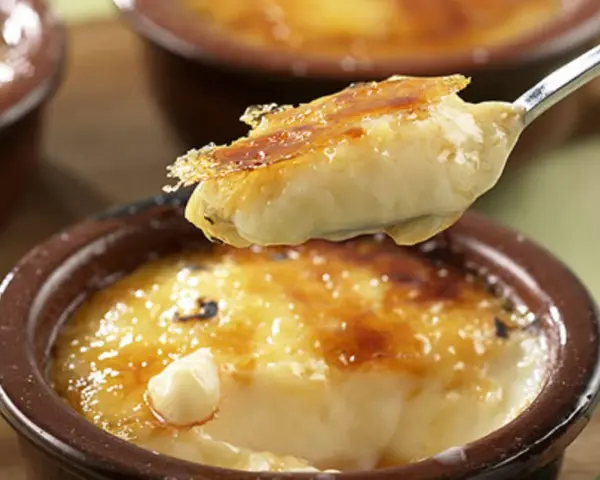 Cremige Crema Catalana Eis wird von einem Löffel aufgetischt, die karamellisierte Kruste bricht.
