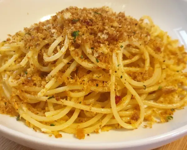 Spaghetti conditi con aglio, olio e abbondante pasta con la mollica croccante.