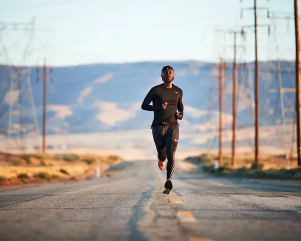 Un uomo corre su una strada deserta, circondato da tralicci dell'alta tensione. La corsa come fuga dalla depressione.