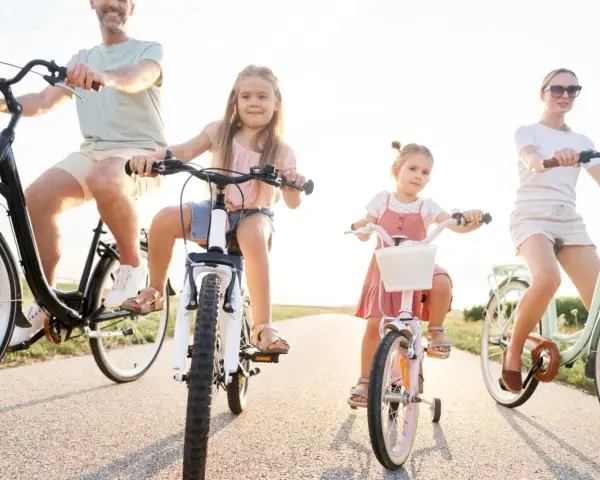 Rodzina na rowerach. Czy karta rowerowa jest obowiązkowa? Dzieci i rodzice cieszą się wspólną przejażdżką.