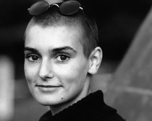 Sinéad O'Connor mit Sonnenbrille auf dem Kopf, ein nachdenklicher Blick. Ihr ikonischer Titel "Nothing Compares 2 U" hallt nach.