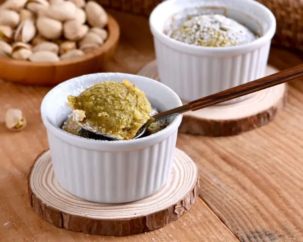 Un delicioso coulant de pistacho, recién horneado y espolvoreado con azúcar glas. ¡Una delicia para los sentidos!