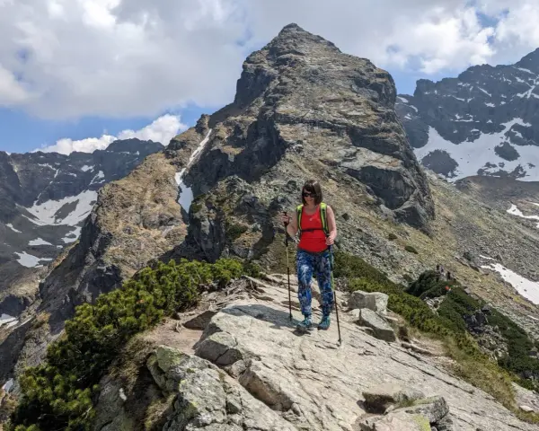 Kobieta z kijkami trekkingowymi na skalistej ścieżce w Tatrach. Czy to szlak dla każdego? Kościelec czeka!