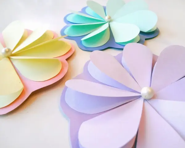 Pyssel vårblommor i pastellfärger. Tre pappersblommor med pärlor i mitten, perfekta för vårens dekorationer.