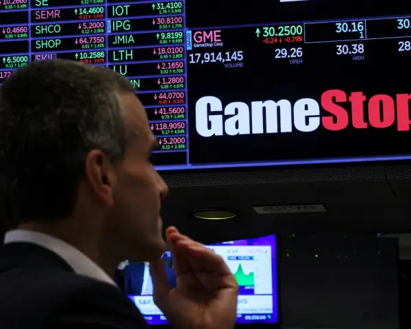 Un hombre observa la pantalla de cotizaciones de GameStop, analizando la previsión de fondos y el comportamiento del mercado.