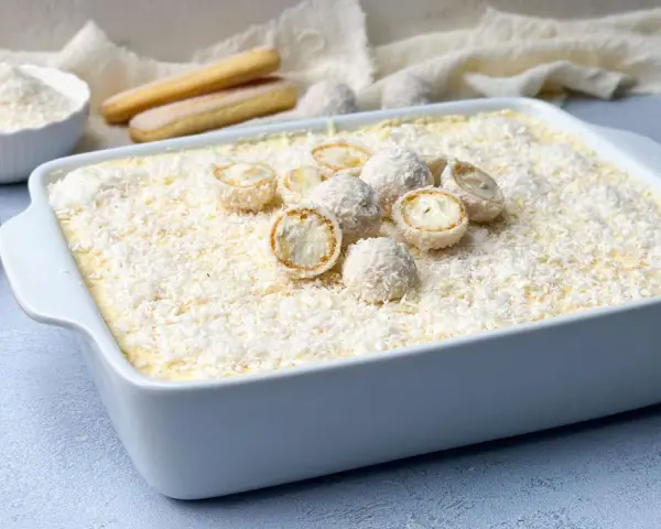 Ein köstliches Raffaello Tiramisu Rezept, das mit Kokosraspeln und süßen Pralinen verziert ist. Perfekt für jeden Anlass!