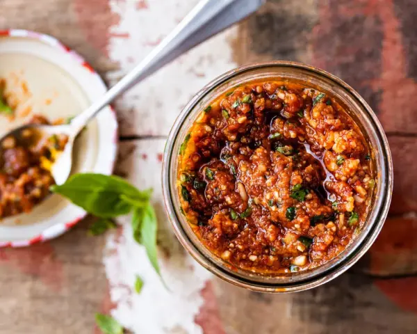 Un pot de pesto rosso maison, prêt à être dégusté. Une recette simple et savoureuse pour relever vos plats.