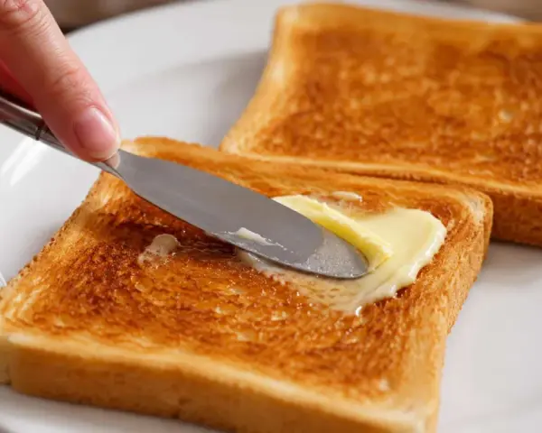 Goldbraunes Brot im Ofen getoastet, wird nun mit Butter bestrichen. Ein Genuss!