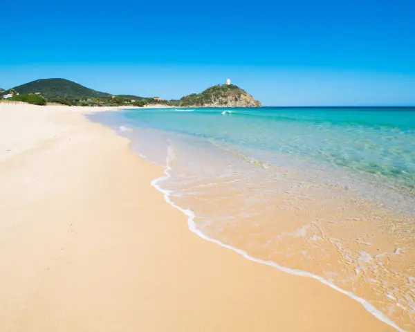 Piękne plaże Cagliari z turkusową wodą i piaszczystym brzegiem. W oddali widać wzgórze z wieżą.