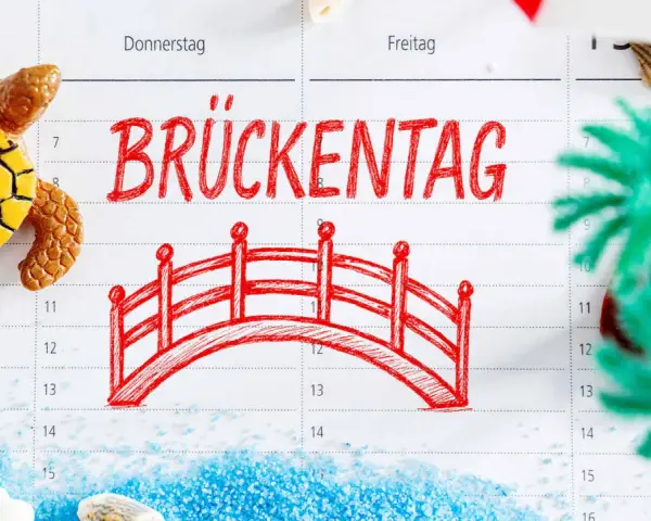 Kalenderblatt mit "Brückentag" und einer roten Brücke, Schildkröte, Muscheln und Dekoration.