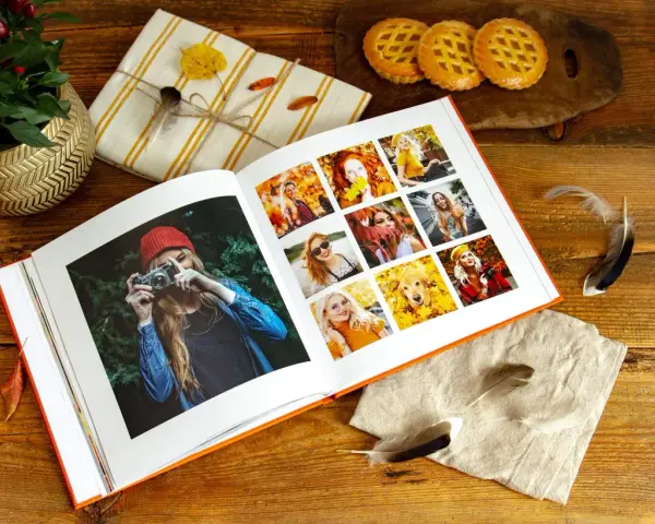 Otwarty album ze zdjęciami, idealny program do segregacji zdjęć, prezentuje jesienne portrety i psa wśród liści.