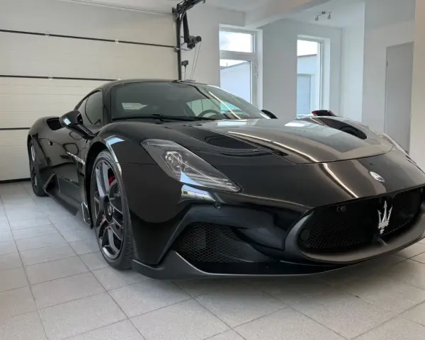 Czarny Maserati MC20 w garażu, widok z przodu.