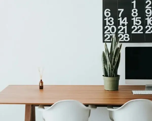 Escritorio moderno con ordenador, planta y calendario. Ideal para organizar tus aplicaciones de escritorio en la nube.