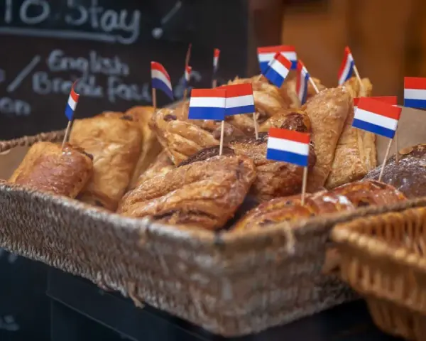 Koszyk pełen słodkości z holenderskimi flagami. Idealne, by dowiedzieć się, co przywieźć z Holandii do jedzenia!