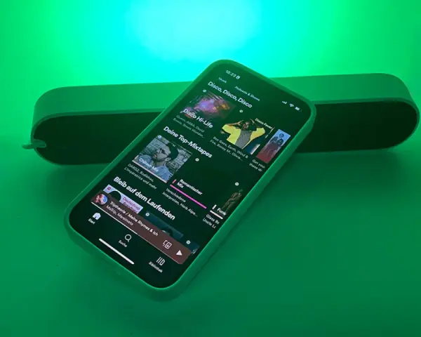 iPhone mit Spotify-App, das Disco-Musik abspielt, beleuchtet von Philips Hue Licht.