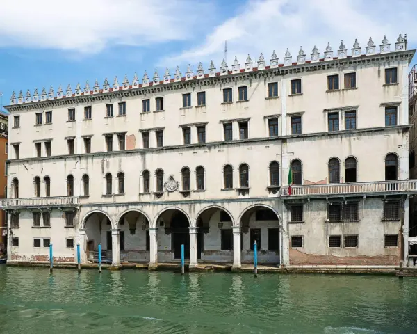 Palazzo sul Canal Grande, un tempo sede dei mercanti tedeschi, con le sue arcate e finestre che riflettono l'acqua di Venezia.