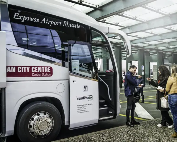 Autobus Express Airport Shuttle z napisem "AN CITY CENTRE Central Station" czeka na pasażerów. Podróż z Mediolan Malpensa do centrum jest prosta.