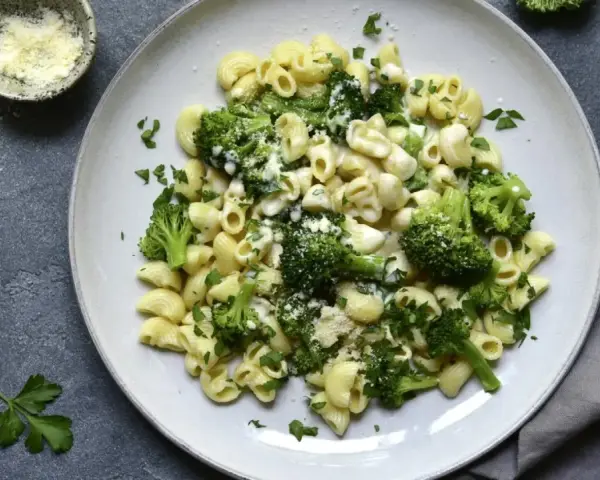 Pasta con brócoli cremosa, espolvoreada con queso rallado y perejil fresco. Un plato sencillo y delicioso.