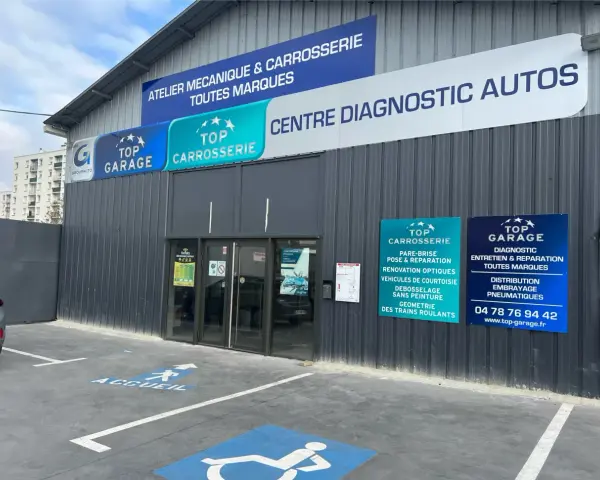 Façade d'un centre automobile avec des panneaux "Top Garage", "Top Carrosserie" et "Centre Diagnostic Autos".