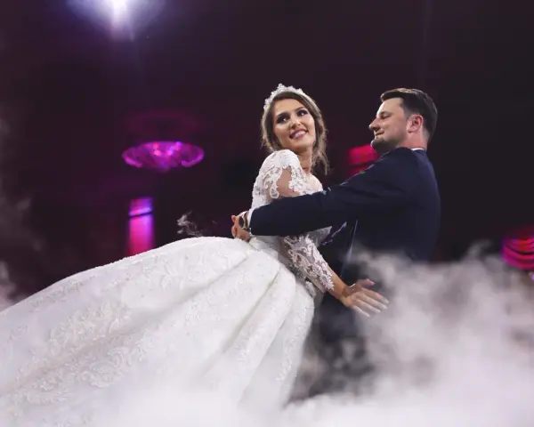 Para młoda tańczy przy dźwiękach energicznych piosenek do tańca polskich, otoczona mgłą.