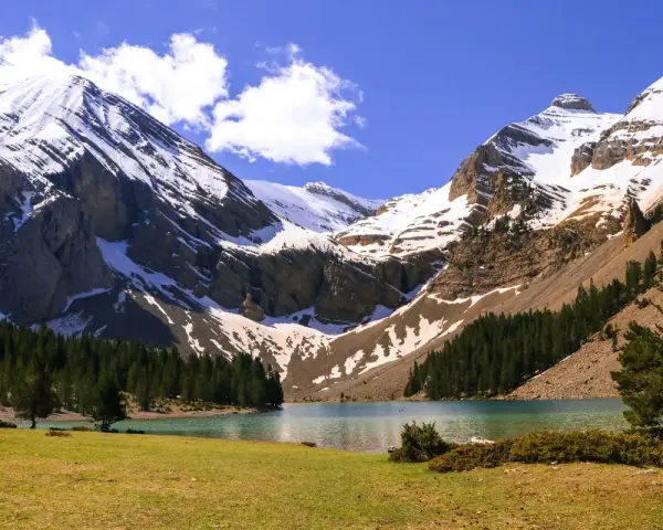 Majestuoso ibón de Plan, rodeado de montañas nevadas y bosques. Un paisaje perfecto para una ruta circular.