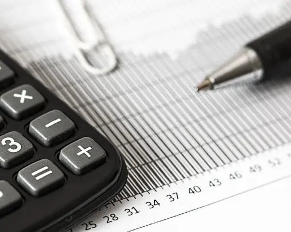 Calculadora y bolígrafo sobre gráficos. El modelo 309 para que sirve se puede deducir de estos elementos de contabilidad.