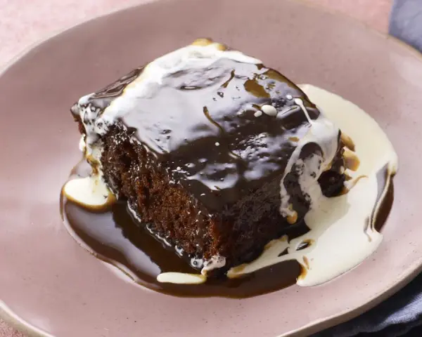 Pyszny Sticky Toffee Pudding przepis. Wilgotne ciasto oblane gorącym sosem toffi i śmietanką.