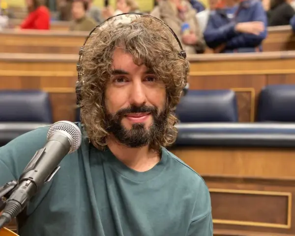 Mikel Izal, con su melena rizada y barba, sonríe ante el micrófono, listo para crear su propio paraíso musical en este escenario.