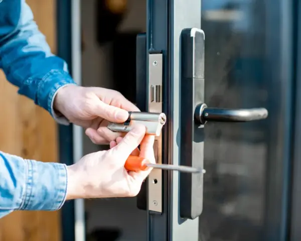 Mani che sostituiscono serratura porta con cacciavite.