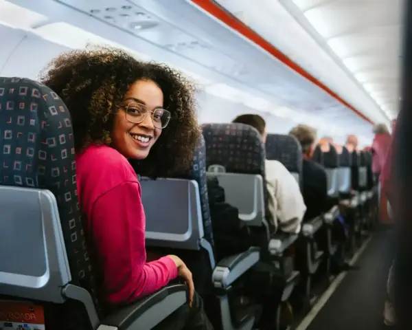 Smiling woman on a discount airlines european flight. She's happy to be traveling affordably.