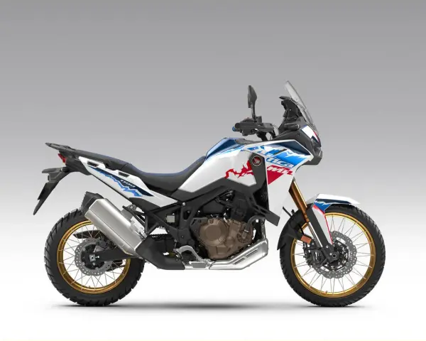 Nowy motocykl Honda Africa Twin 1100 w białym malowaniu z niebieskimi i czerwonymi akcentami, gotowy na przygodę.