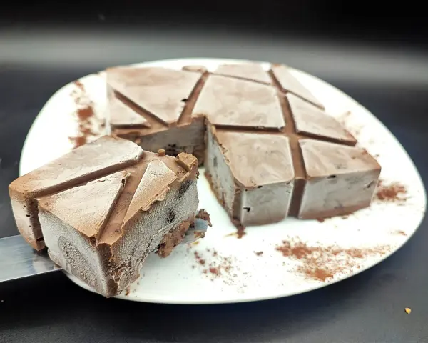 Un delizioso semifreddo al cioccolato, tagliato a cubetti e spolverato con cacao, pronto per essere gustato.