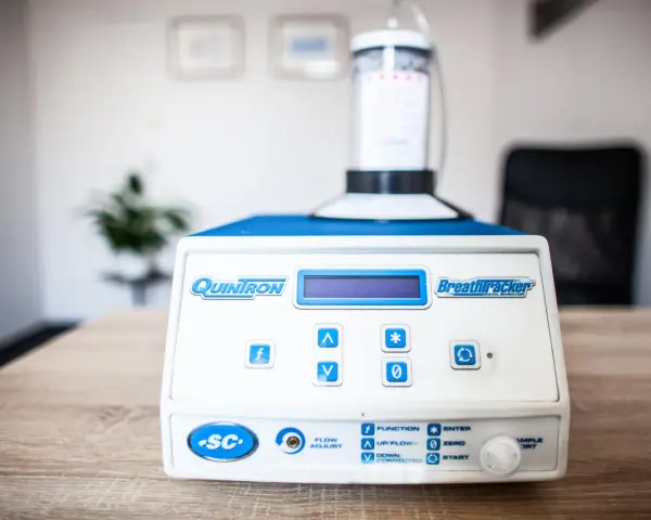 Urządzenie QuinTron BreathTracker do analizy oddechu na stole.