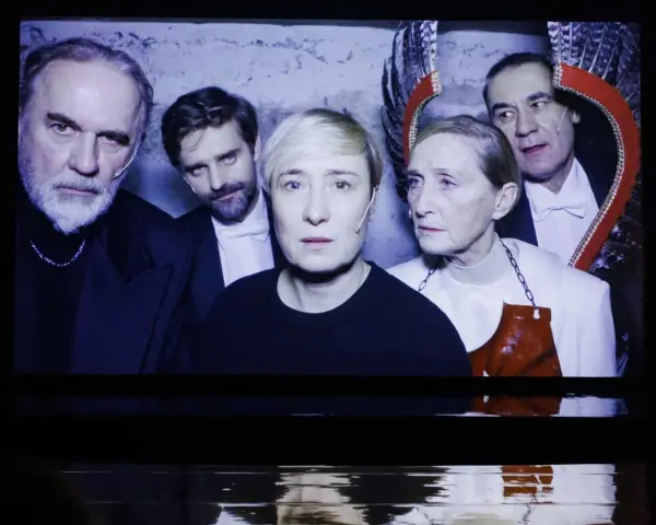 Kazimierz, reżyser i aktor teatralny, w otoczeniu aktorów na scenie.