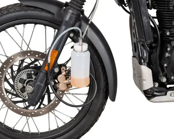 Przygotowanie motocykla do jazdy: odpowietrzanie hamulców z ABS. Widać koło, tarczę hamulcową i zbiorniczek z płynem.