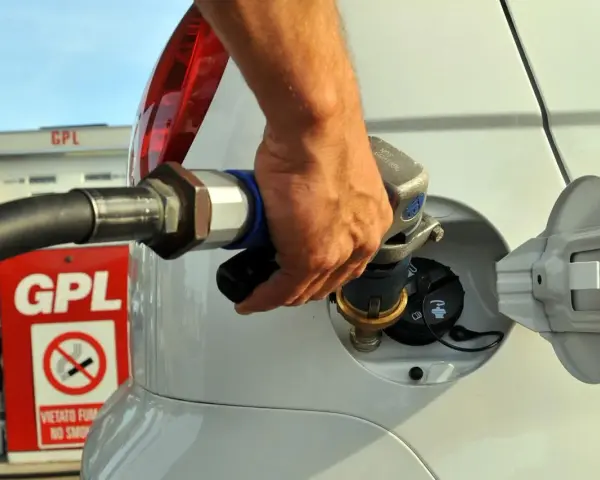 Rifornimento GPL in autostrada. Mano che inserisce la pistola nel serbatoio dell'auto.
