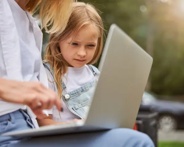 Mama z córką przeglądają internet, szukając informacji, kiedy jest rekrutacja do żłobka.