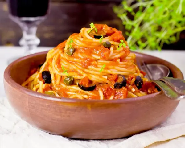En härlig portion spaghetti med en smakrik tomatsås, oliver och kapris. Perfekt vin till pasta puttanesca.