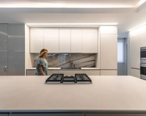 Cocina moderna con iluminación LED integrada en los gabinetes y el techo, ideal para saber como iluminar una cocina.