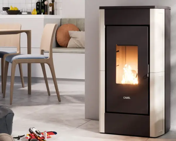 Stufa a pellet moderna in funzione, con fiamme vive. L'installazione stufa a pellet con canna fumaria è discreta, integrata in un ambiente cucina/soggiorno accogliente.