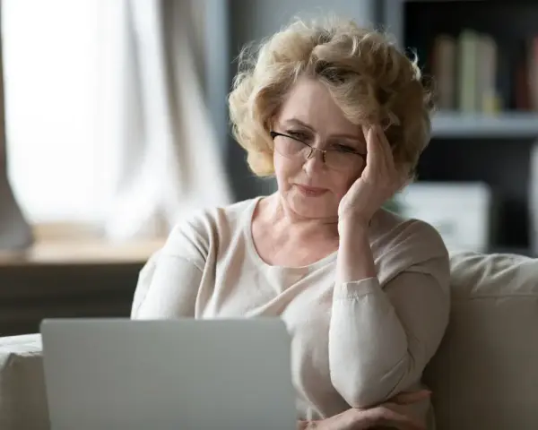 Zmartwiona wdowa po 50. roku życia szuka informacji o rencie rodzinnej online.