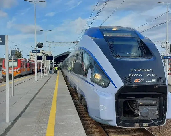 Nowoczesny pociąg PKP Intercity ED161 na peronie, obok innego pociągu.