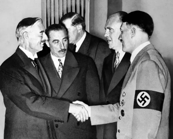 Neville Chamberlain y Adolf Hitler se dan la mano en la conferencia de Múnich, un momento clave de la historia.