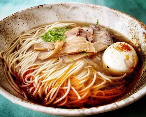 Miseczka aromatycznego ramenu z makaronem, jajkiem, mięsem i bambusem. Idealny przepis, jak zrobić ramen.