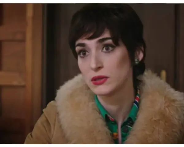 Una donna con un taglio di capelli corto e scuro, trucco marcato e un cappotto di pelliccia chiara. Le anticipazioni di Cuori 3 promettono colpi di scena.