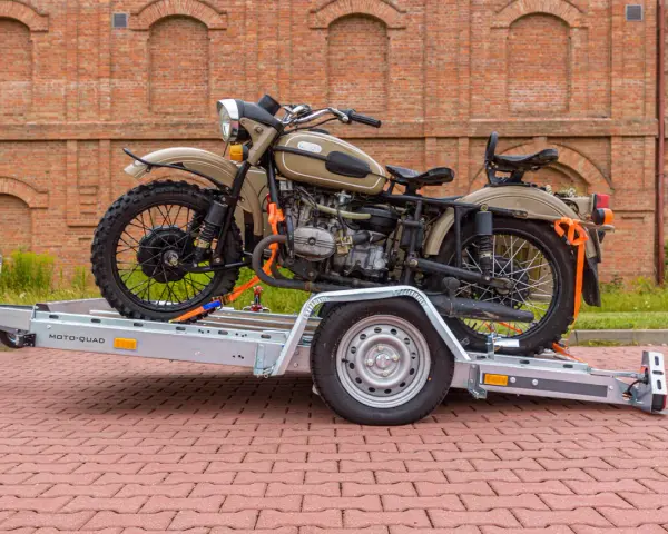 Jak przewieźć motocykl? Na przyczepie MOTO-QUAD, zabezpieczony pasami. Klasyczny motocykl z wózkiem bocznym czeka na transport.