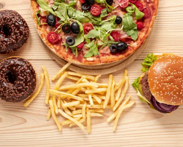 Pizza, burger, frytki i pączki z czekoladą – uczta pełna tłuszczów nasyconych.