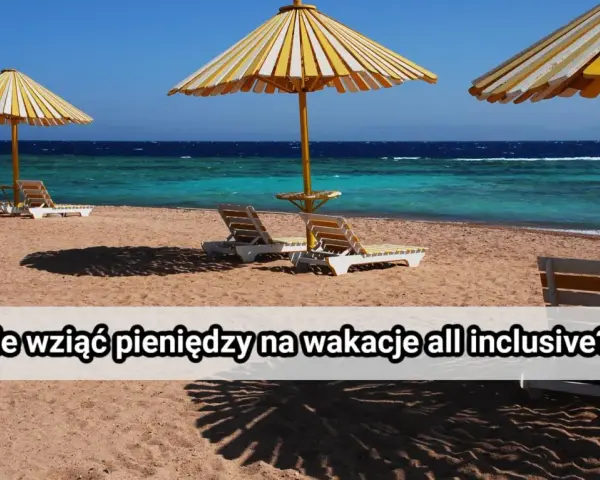 Plaża z leżakami i parasolami pod żółto-białymi pasami, turkusowe morze i błękitne niebo.