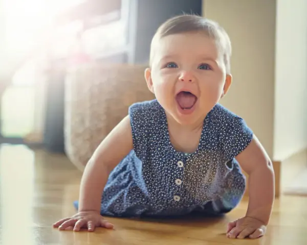 Ein fröhliches Baby hebt Arme und Beine in Bauchlage, bereit zum Krabbeln.