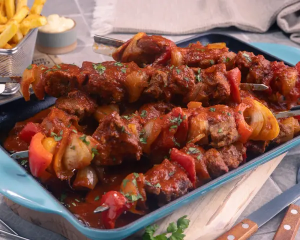 Herzhaftes Schaschlik im original Rezept-Stil, mit saftigem Fleisch, Paprika und Zwiebeln in würziger Sauce. Dazu knusprige Pommes.